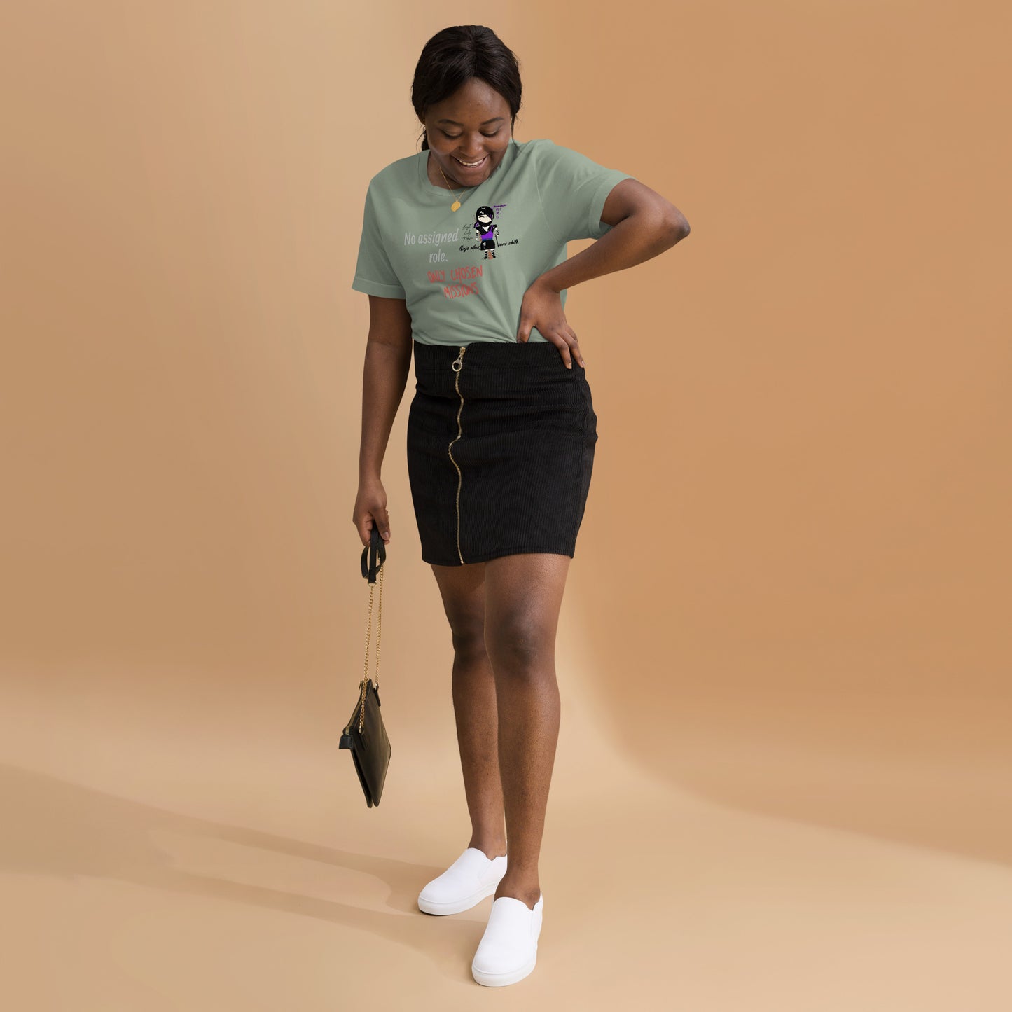 Woman wearing a green t-shirt with text and a playful lady ninja graphic design on a beige background